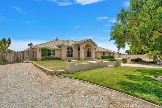 mediterranean / spanish-style house with a front yard