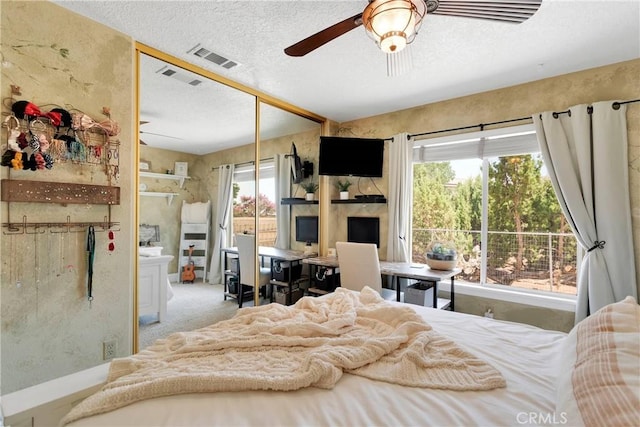 bedroom featuring a textured ceiling, ceiling fan, light carpet, and a closet