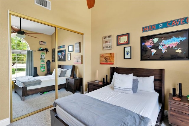 carpeted bedroom featuring ceiling fan and a closet