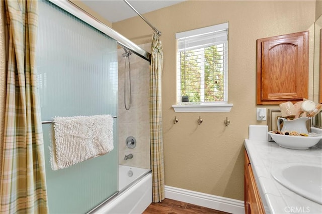 bathroom with hardwood / wood-style floors, vanity, and bath / shower combo with glass door