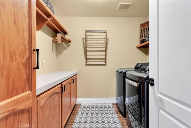 washroom featuring washer and clothes dryer, cabinets, and hardwood / wood-style floors