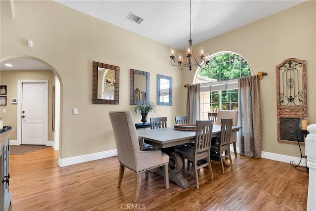 dining room featuring light wood-type flooring and a notable chandelier