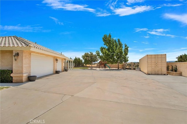 view of patio / terrace with a playground and a garage