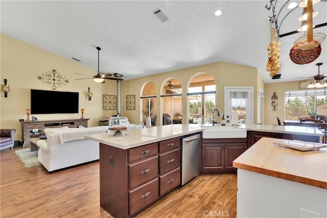 kitchen featuring light wood-type flooring, stainless steel dishwasher, ceiling fan, sink, and lofted ceiling