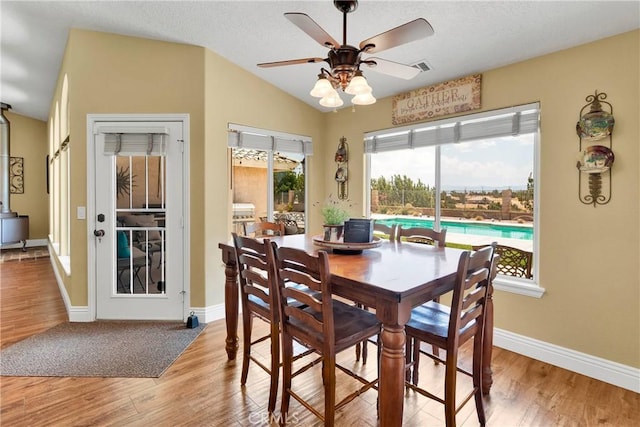 dining space featuring ceiling fan, a healthy amount of sunlight, lofted ceiling, and light hardwood / wood-style floors