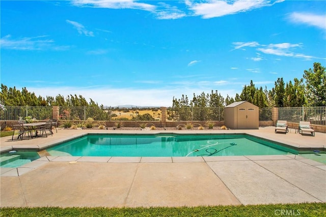 view of swimming pool with a patio and a storage shed