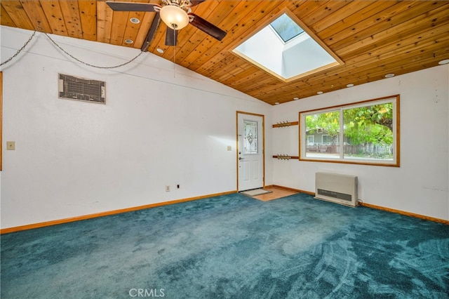 carpeted empty room featuring ceiling fan, heating unit, vaulted ceiling with skylight, and wood ceiling