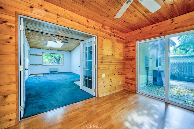 spare room with ceiling fan, a skylight, hardwood / wood-style flooring, and plenty of natural light