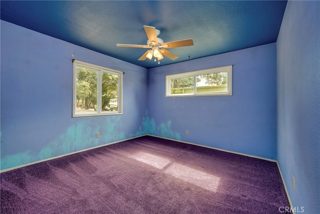 carpeted empty room with a textured ceiling and ceiling fan