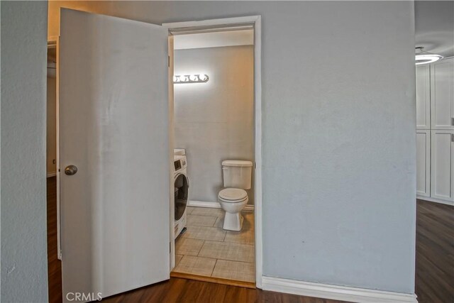 1108 Camino Real Unit 510, Redondo Beach, CA 90277 - bathroom with toilet, washer / clothes dryer, wood finished floors, and baseboards