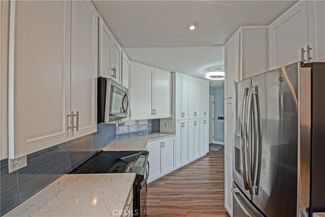 1108 Camino Real Unit 510, Redondo Beach, CA 90277 - kitchen featuring stainless steel appliances, white cabinetry, light stone counters, and tasteful backsplash