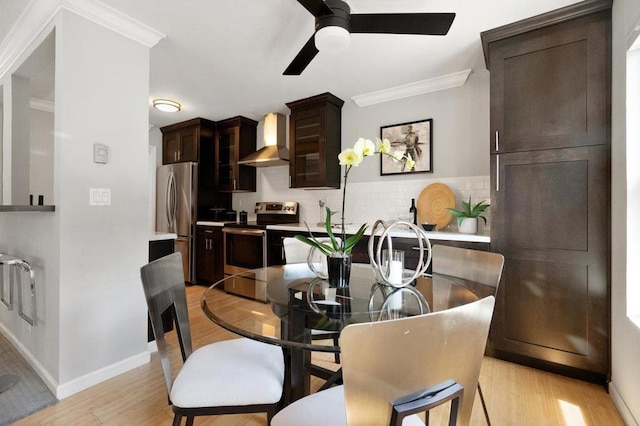 dining space featuring ceiling fan, crown molding, and light wood-type flooring