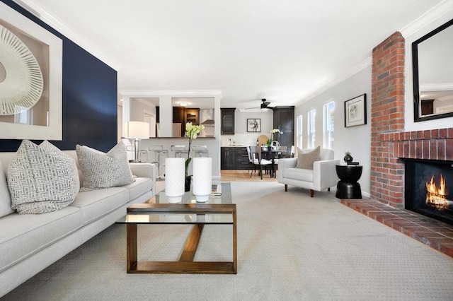 carpeted living room featuring ceiling fan, a brick fireplace, and ornamental molding