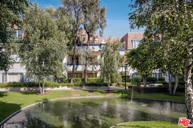 surrounding community featuring a water view and a lawn