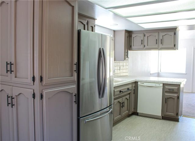 kitchen featuring white dishwasher and stainless steel refrigerator