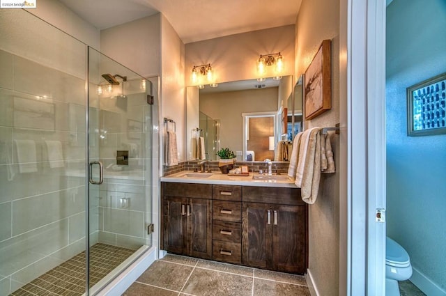 bathroom with tile patterned flooring, vanity, an enclosed shower, and toilet