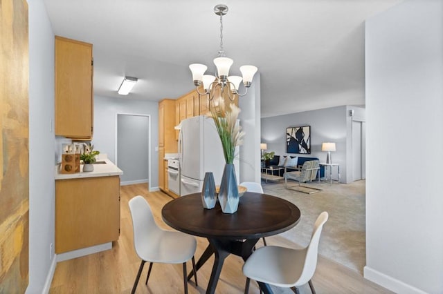 dining room with an inviting chandelier and light hardwood / wood-style flooring