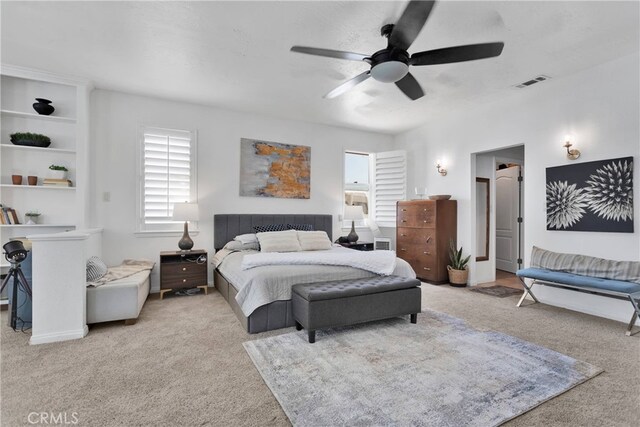 carpeted bedroom featuring multiple windows and ceiling fan