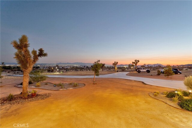 yard at dusk featuring a mountain view