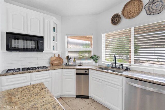 kitchen featuring white cabinetry, light tile patterned floors, sink, light stone countertops, and appliances with stainless steel finishes