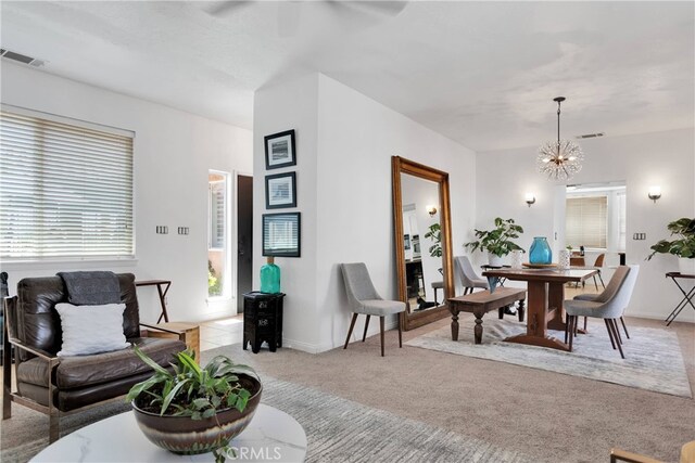 living room with a chandelier and light colored carpet