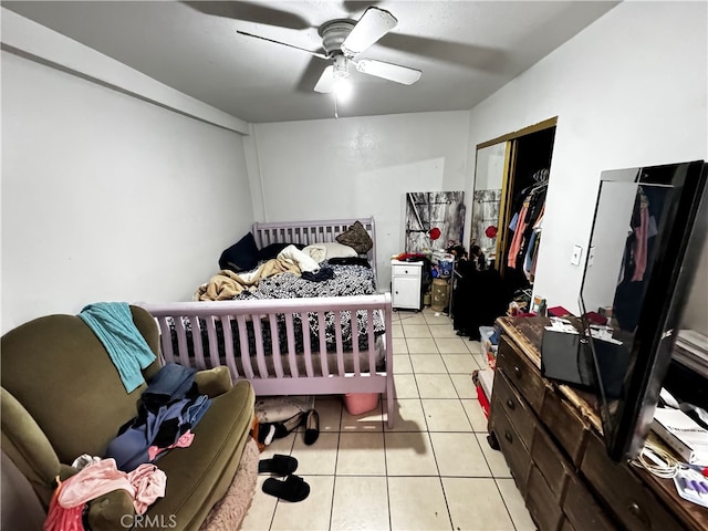 tiled bedroom featuring ceiling fan and a closet