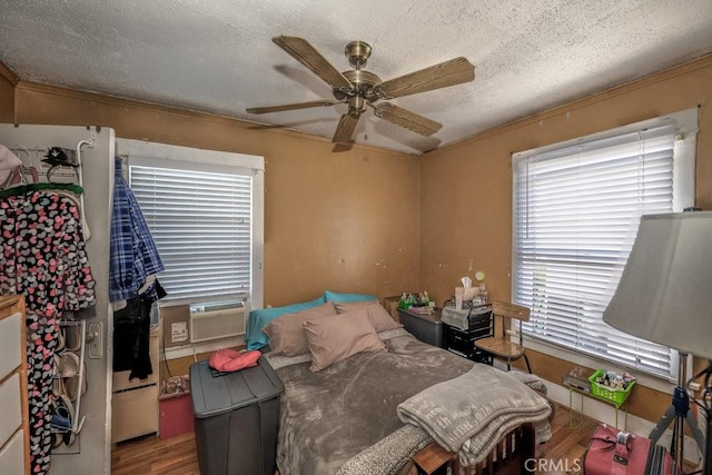 bedroom with crown molding, multiple windows, wood finished floors, and cooling unit