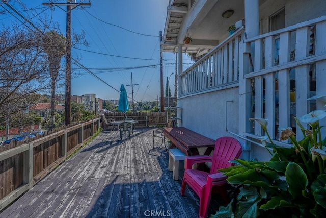 deck featuring outdoor dining area and fence