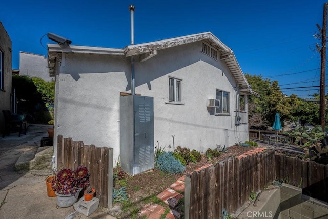 view of property exterior featuring fence, a patio, and stucco siding