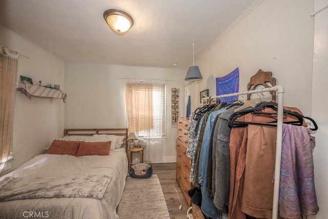 bedroom with hardwood / wood-style flooring and ornamental molding