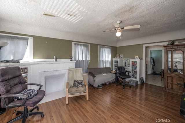 bedroom with a ceiling fan, a textured ceiling, and wood finished floors