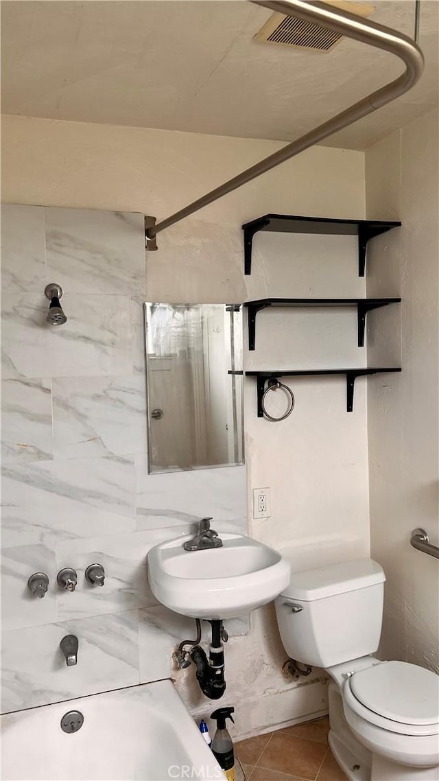 bathroom with a sink, tile patterned floors, and toilet