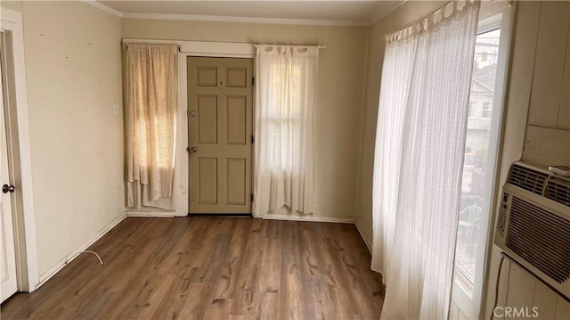 interior space featuring baseboards, ornamental molding, and wood finished floors