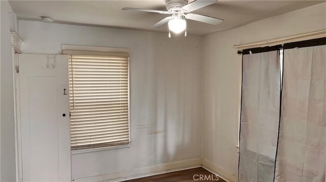 spare room with a ceiling fan, baseboards, and wood finished floors