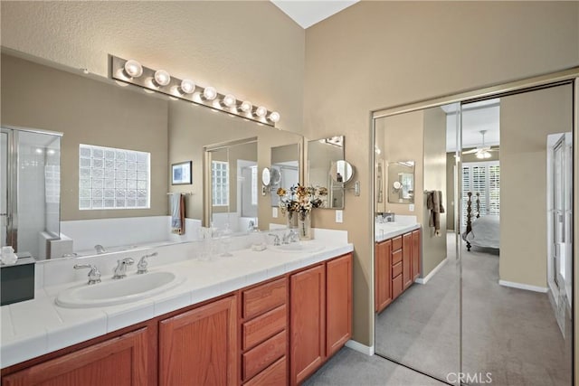 ensuite bathroom with a sink, a garden tub, double vanity, and connected bathroom