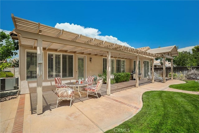 rear view of house featuring fence, a lawn, stucco siding, a pergola, and a patio area