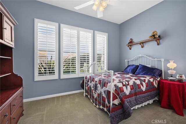 carpeted bedroom featuring multiple windows and ceiling fan