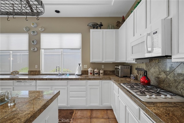 kitchen with white appliances, sink, decorative backsplash, light tile patterned flooring, and white cabinetry