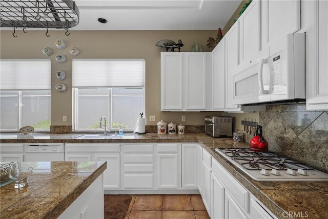 kitchen with tile countertops, white appliances, a sink, and white cabinets