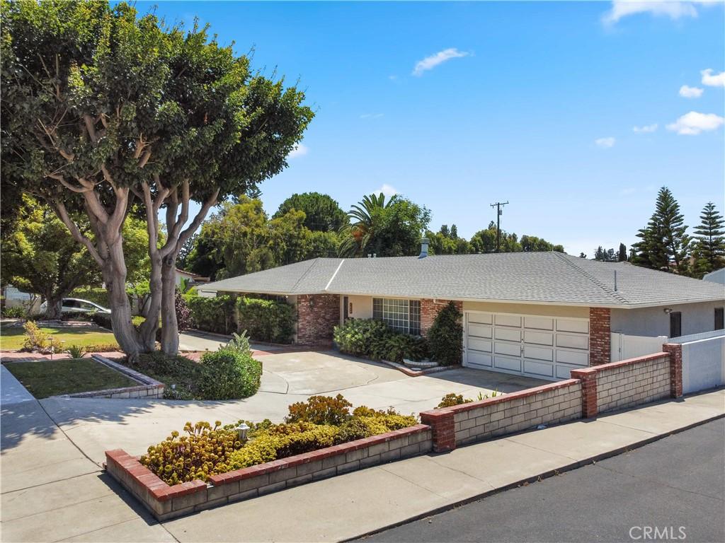 ranch-style home featuring driveway, brick siding, and an attached garage