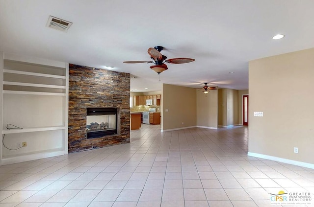 unfurnished living room featuring built in features, ceiling fan, a stone fireplace, and light tile patterned flooring