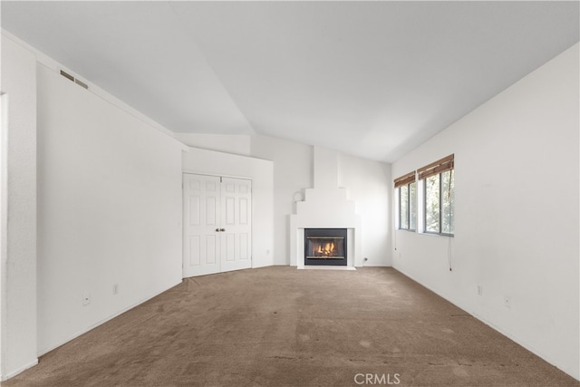 unfurnished living room featuring carpet floors and vaulted ceiling