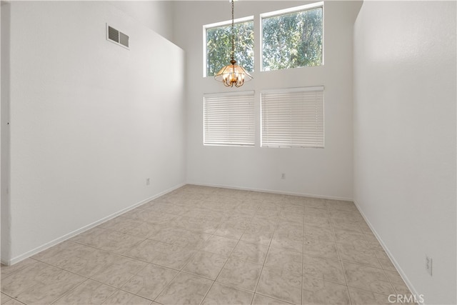 tiled empty room with a notable chandelier