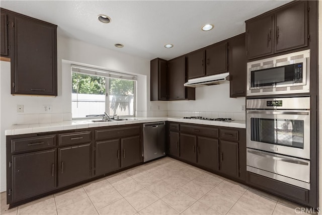 kitchen featuring sink, stainless steel appliances, and dark brown cabinetry