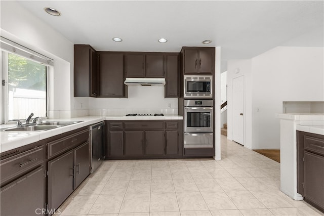 kitchen featuring light tile patterned flooring, sink, stainless steel appliances, and dark brown cabinetry