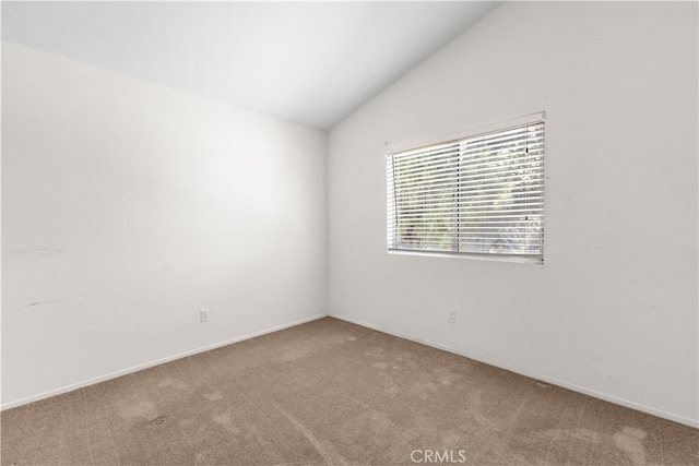 unfurnished room with vaulted ceiling and carpet flooring