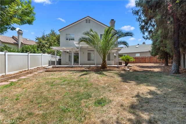 rear view of house with a pergola, a lawn, and a patio area