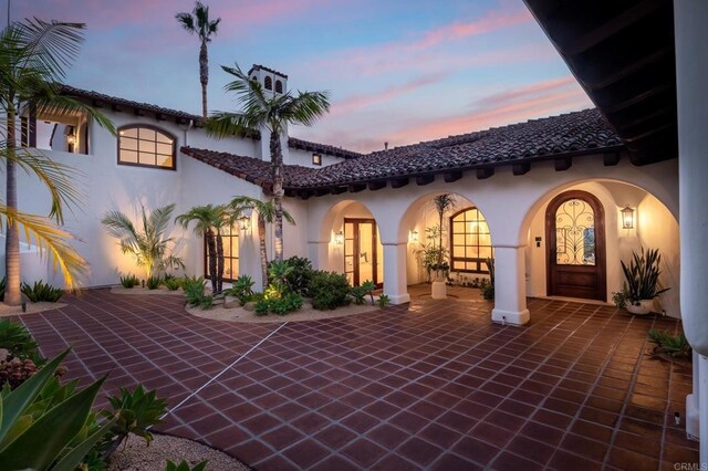 back house at dusk with a patio