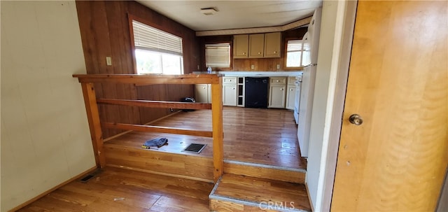 interior space featuring wood-type flooring, dishwasher, and white cabinetry