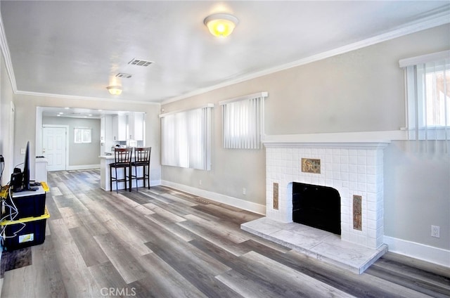 living room with a fireplace, wood-type flooring, and ornamental molding